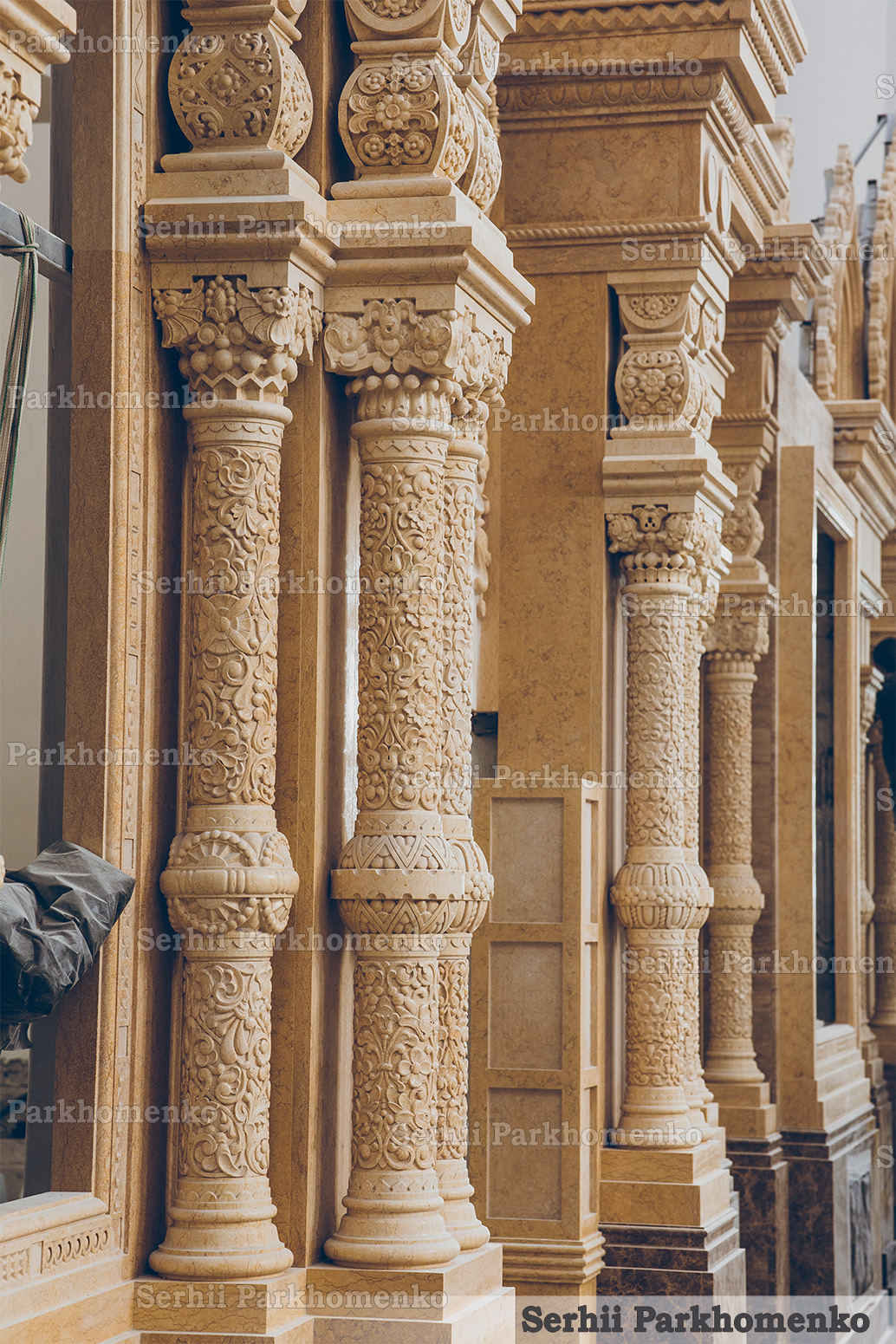 Ornate custom-carved stone columns and classical facade architectural elements installed on-site by Serhii Parkhomenko's studio