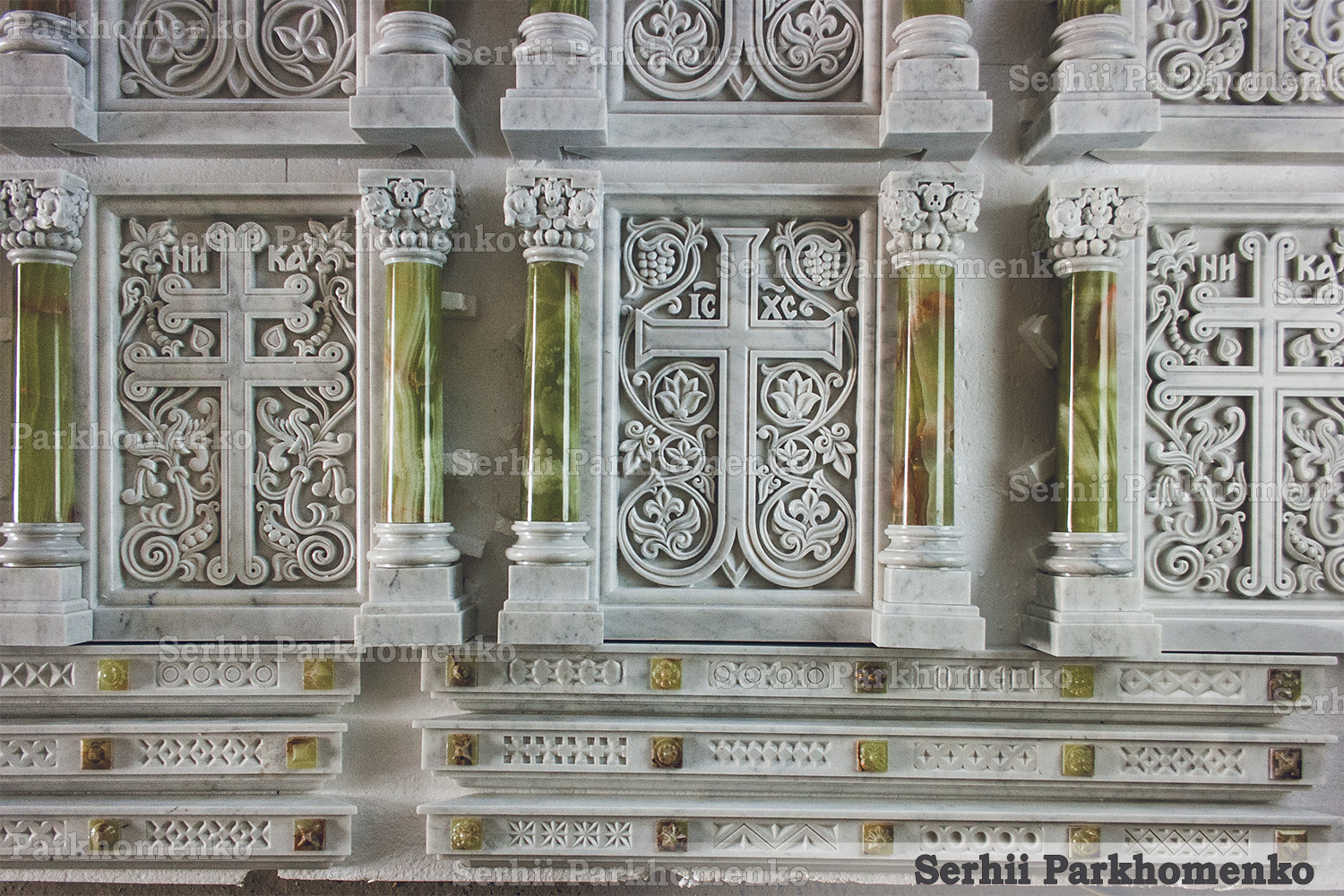 Frontal view of custom Neo-Byzantine stone reliefs showcasing intricate marble crosses and green onyx pillars