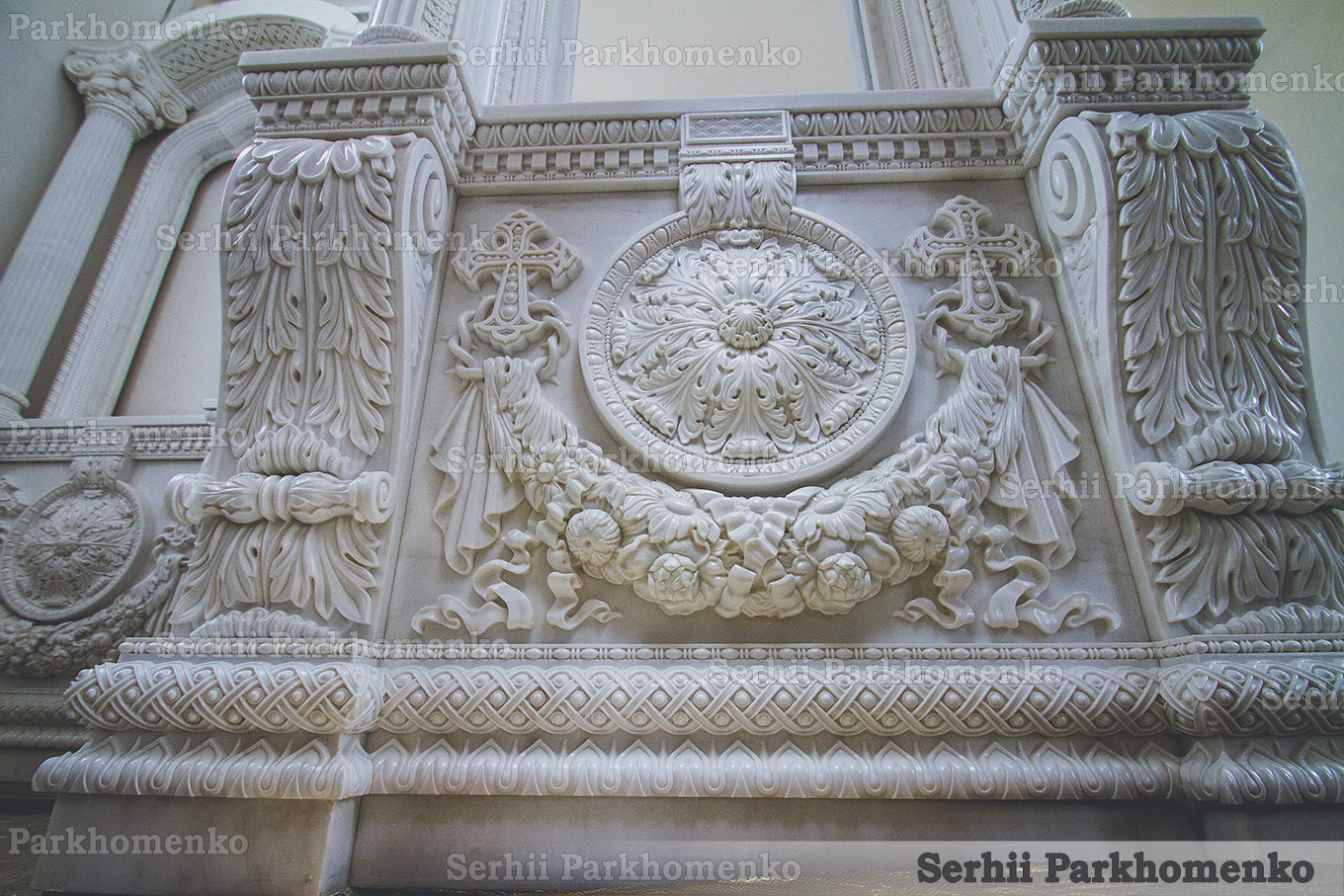 Close-up of a masterfully carved white marble iconostasis base with a floral rosette and cross relief at the St. Sergius Chapel