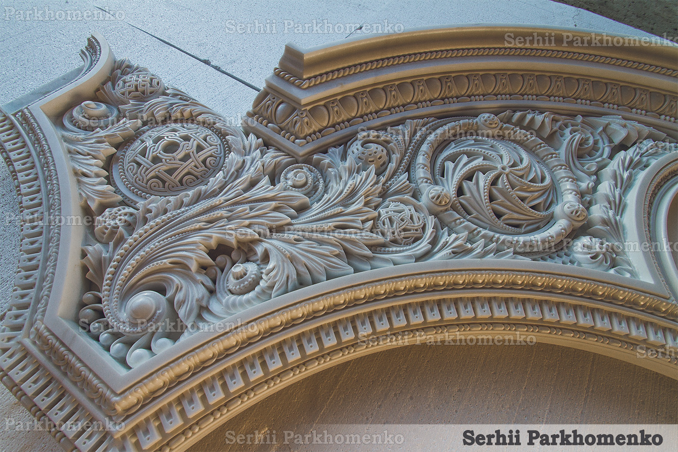 Close-up perspective of the intricate high-relief foliage and braided rosettes on an architectural marble portal