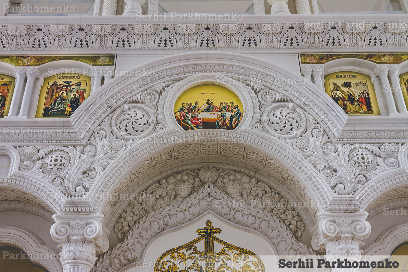 Detailed view of the Neo-Byzantine style carved marble arch above the Holy Doors featuring a Last Supper icon at the St. Sergius Chapel