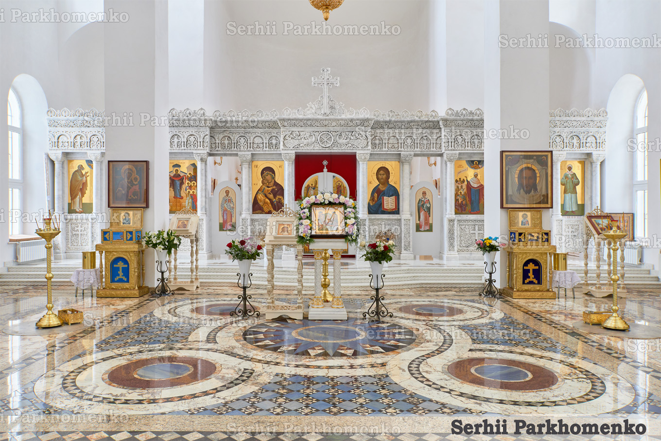 Grand church interior design showcasing a carved single-tier white marble iconostasis and a majestic polychrome stone rosette floor