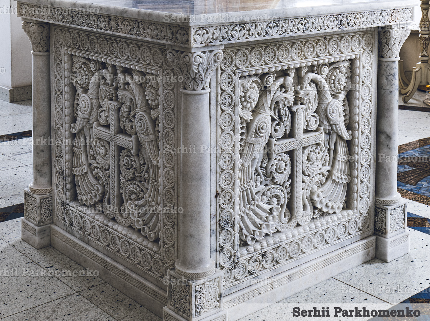 Three-quarter view of a Neo-Byzantine style Altar Table made of Mugla White marble with intricate carvings of peacocks and crosses by Serhii Parkhomenko's studio