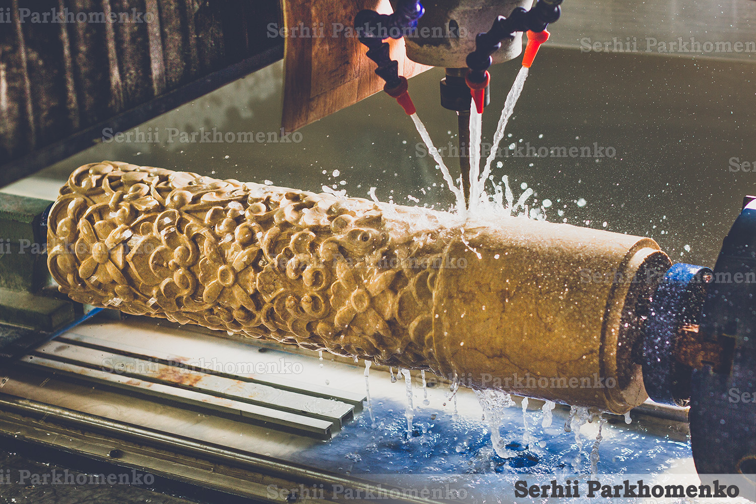 CNC milling machine carving an intricate floral pattern on a stone column with water cooling at Serhii Parkhomenko's studio