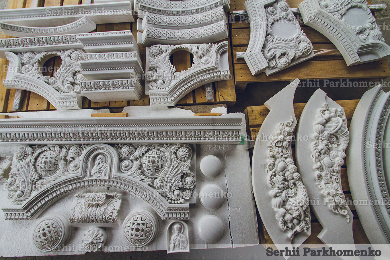 Finished architectural stone elements and carved bas-reliefs in the workshop, prepared for delivery to the project site