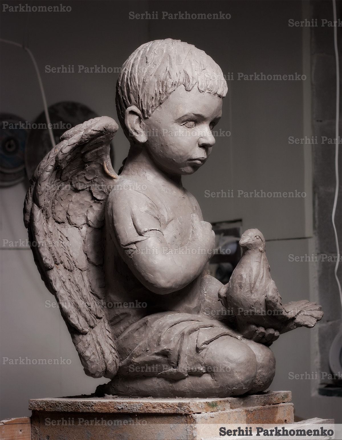 Artistic clay model process of a kneeling angel sculpture with a dove by Serhii Parkhomenko's Studio