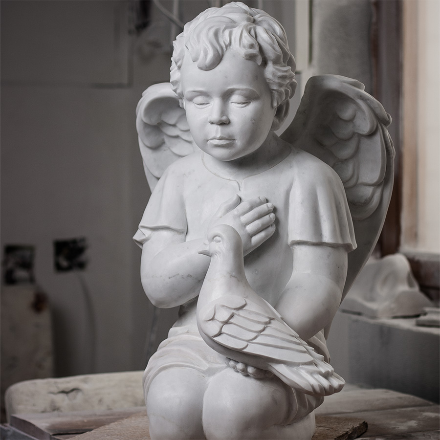 The sculpture of the marble angel with a dove